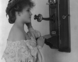 Woman speaking into wall mounted telephone, 1905 Woman speaking into wall mounted telephone, 1905